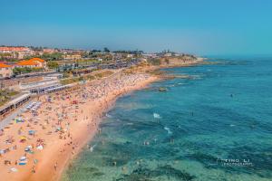 a beach with a lot of people in the water at Gold Coast Photography Inn in Estoril