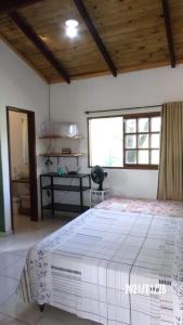 una camera da letto con un grande letto bianco e una finestra di Chalé Nova Aurora a Alto Paraíso de Goiás