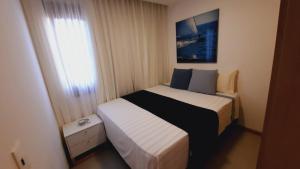 a small bedroom with a bed and a window at Apartamento Portofino in Barra Grande