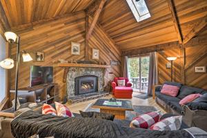 a living room with a fireplace in a log cabin at Riverfront Gold Bar Cabin with Hot Tub and Mtn Views! in Gold Bar