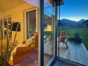 a screened in porch with a view of the mountains at TYROL PURElife Lodges in Sankt Jakob in Defereggen