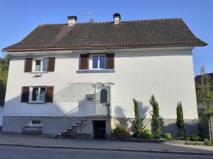 a large white house with a balcony on a street at Chalet zum See in Bregenz