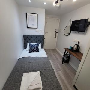 niewielka sypialnia z łóżkiem i telewizorem w obiekcie Argyle Square Hotel w Londynie