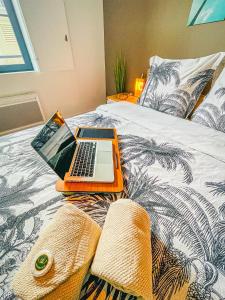 an orange laptop computer sitting on top of a bed at Caribbean Spirit in Périgueux