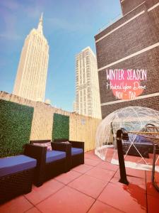 un patio avec deux bancs et un panneau sur un bâtiment dans l'établissement Hotel and the City, Rooftop City View, à New York