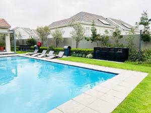 a swimming pool in front of a house at Quebec Apartments - Fully Furnished & Equipped 1 Bedroom Apartment in Sandton