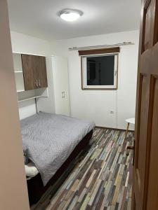 een kleine slaapkamer met een bed en een televisie bij Apartman D&D Šišava Vlašić in Vlasic