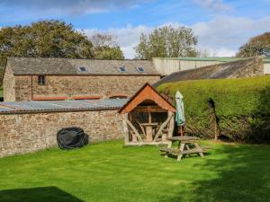 a tent and a picnic table in front of a building at Pillhead Cider House in Bideford
