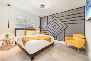 a bedroom with a bed and a yellow chair at Deluxe Miami House w 5BR Mini Golf & Heated Pool L62 in Miami +31 photos