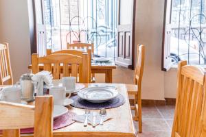 einem Holztisch mit Tellern und Utensilien darauf in der Unterkunft Hotel Meson de Carolina in Querétaro