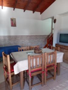 comedor con mesa, sillas y TV en Cabañas bajos medanales en Victorica