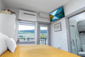 a bedroom with a large bed and a window at Top Floor on Okanagan Lake with AC & Heated Pool in Vernon