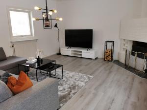a living room with a couch and a flat screen tv at The Red and White House in Luleå