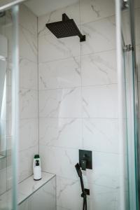a bathroom with a shower and a white marble wall at Hercegovina apartments in Mostar