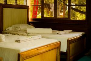 2 camas individuales en una habitación con ventana en Hotel Bahía Aguacate en Capurganá