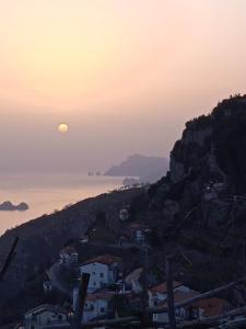 een uitzicht op de zonsondergang boven de oceaan bij Residence Eden in Furore