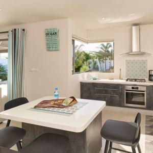 Villa Primera 3 bedroom bungalow with private pool Grand Bay في غراند بايَ: مطبخ مع طاولة وكراسي في مطبخ