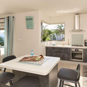 a kitchen with a table and chairs in a kitchen at Villa Primera 3 bedroom bungalow with private pool Grand Bay in Grand Baie +16 photos