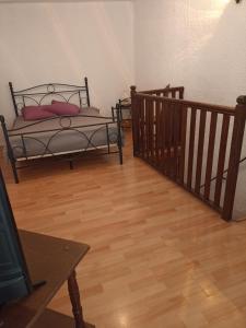 a room with two beds and a wooden floor at Duplex meublé Mercantour in Fontan