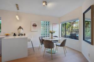 a kitchen and dining room with a table and chairs at Elegant 2BR Family Home - Aircon - 5min to Beach in Auckland