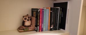 Un estante con libros y una estatua de búho. en InCentRho en Rho