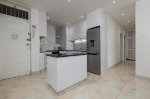 a kitchen with white cabinets and a refrigerator at Sea Lodge Umhlanga Rocks in Durban