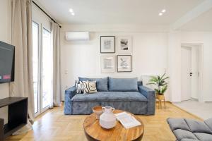 a living room with a blue couch and a table at Athens Delight Apartment in Pagrati in Athens