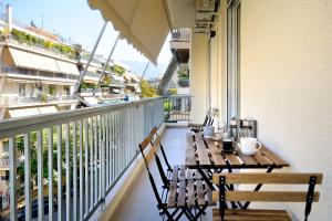 a balcony with a table and chairs on a balcony at Athens Delight Apartment in Pagrati in Athens