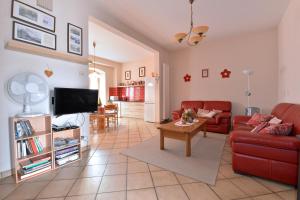 a living room with a red couch and a tv at S'Harzala Rouge in Bergheim