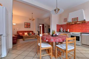 eine Küche und ein Wohnzimmer mit einem Tisch und Stühlen in der Unterkunft S'Harzala Rouge in Bergheim