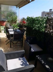 patio ze stołem, krzesłami i roślinami w obiekcie Évasion aux Portes de Cannes 100m2 Lumineux 2 Chambres Terrasse et Commerces w mieście Le Cannet