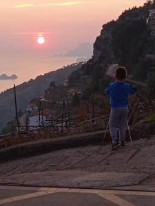 Un ragazzo in piedi su una collina con due pali di Residence Eden a Furore