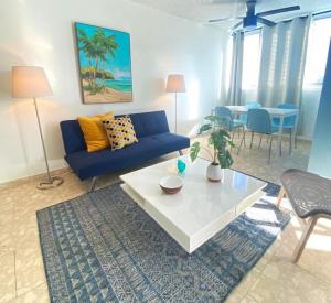 sala de estar con sofá azul y mesa en KASA Royal Palms, en San Juan