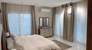1 dormitorio con cama blanca y espejo en بيت السمو en El Cairo