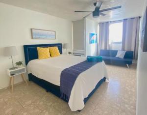 a bedroom with a large bed and a blue couch at KASA Royal Palms in San Juan