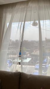 a window with white curtains and a table and chairs at بيت السمو in Cairo