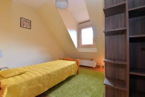 Habitación pequeña con cama y ventana en S'Harzala Jaune, en Bergheim