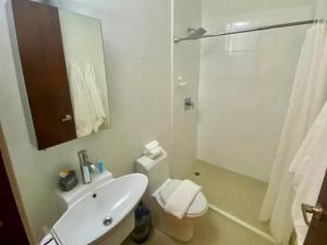 a bathroom with a sink and a toilet and a mirror at KASA The Lofts 302 in San Juan