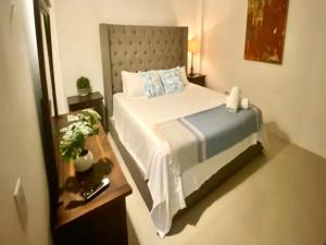 1 dormitorio con 1 cama grande y espejo en KASA The Lofts 302, en San Juan