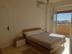 a bedroom with a bed and a large window at Casa Flegrea Bagnoli in Naples