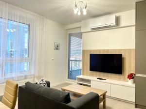 uma sala de estar com um sofá e uma televisão de ecrã plano em Top KamzikTower View em Bratislava