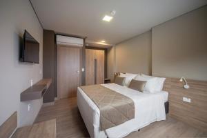 Habitación de hotel con cama y TV en Golden Gramado Lagueto Resort en Gramado