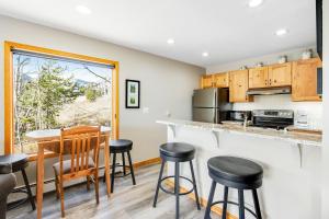 a kitchen with a counter and bar stools at Watch Hill 216 in Silverthorne