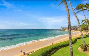 una spiaggia con palme e l'oceano di Kiahuna Plantation Unit 320 - Ground Floor Garden View, Air Conditioning a Koloa