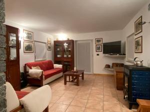 een woonkamer met een rode bank en een tv bij Casa Schiappo Montagna Natura e Relax. 
