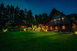 duży dom z zielonym trawnikiem w nocy w obiekcie Cottage: AŽ PO UŠI („Head over heels“) w mieście Sloup