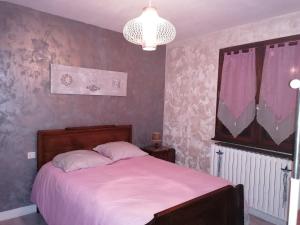 a bedroom with a large bed with a pink blanket at Les Vosges ça vous tente ? in Saint-Nabord