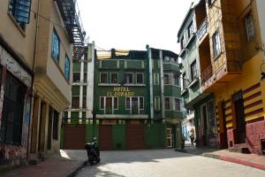 un bâtiment vert au milieu d'une rue dans l'établissement Hotel El Dorado La Candelaria, à Bogotá