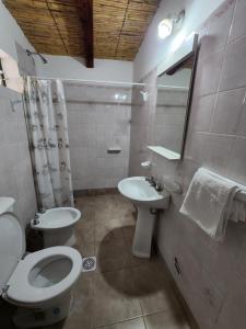 La salle de bains blanche est pourvue de toilettes et d'un lavabo. dans l'établissement HOSPEDAJE LA CASONA DE CACHI, à Cachí