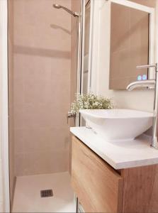 y baño con lavabo blanco y ducha. en Precioso apartamento en el centro de Santander, en Santander